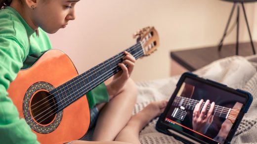 dziewczynka uczy się gry na gitarze online