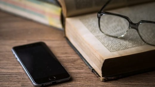 Książka, okulary i telefon leżące na stole
