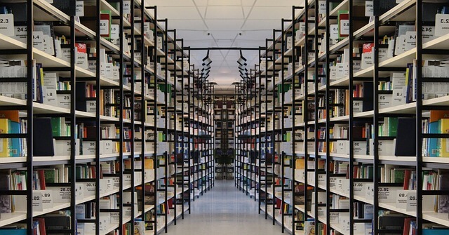 Równolegle ułożone półki z książkami w bibliotece